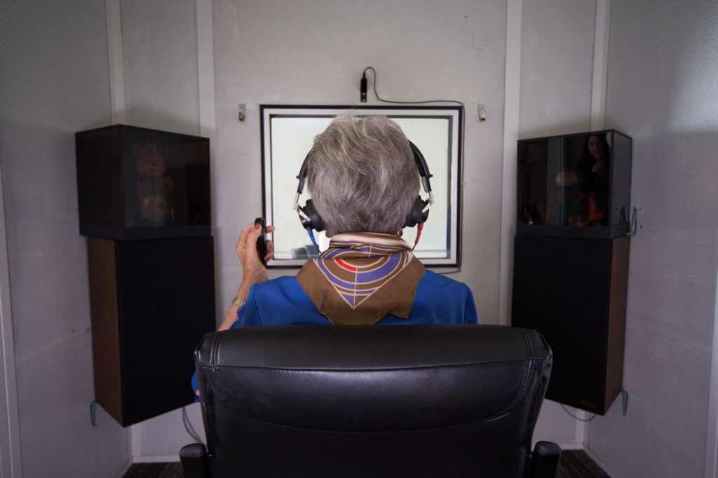 hearing assessment in Toronto with a patient completing a hearing test in a sound booth.