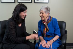 Why can I hear but not understand speech? Audiologist showing hearing aids to a patient who can hear but not understand speech